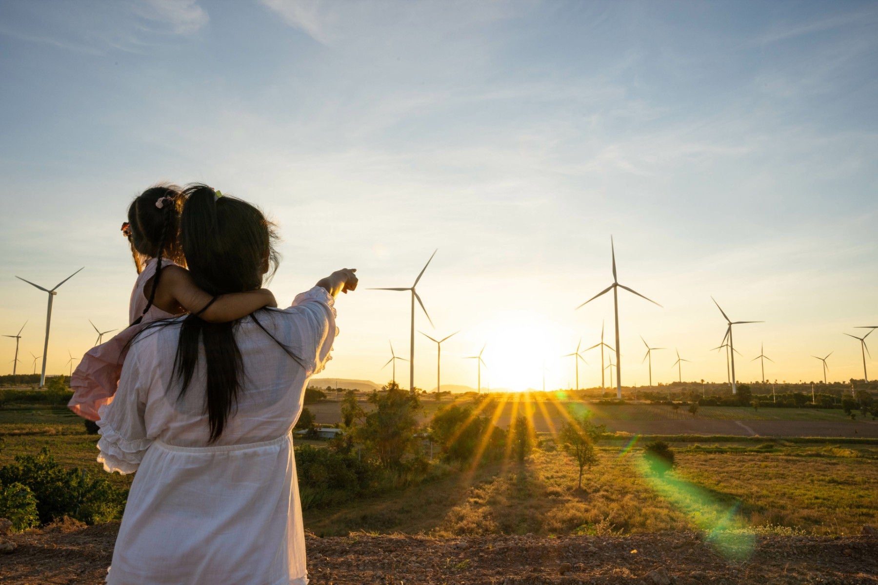 Frau und Kind betrachten den Horizont in einem Windpark