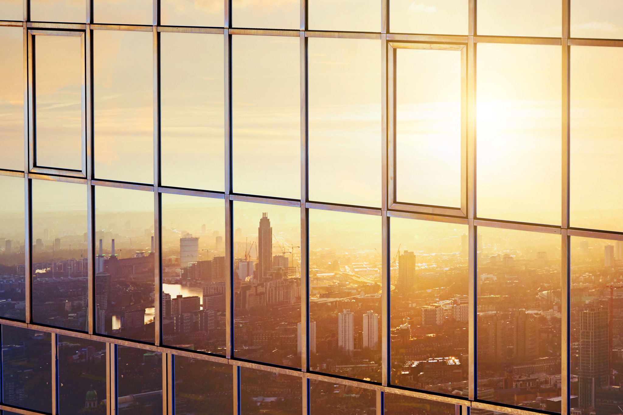 The city at sunrise reflected in a sky scraper. 