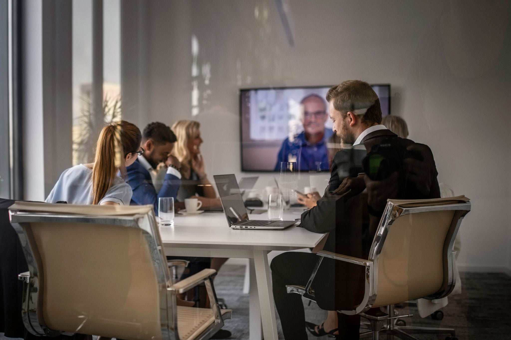 Business people having a meeting and a video conference in a modern office conference room. 